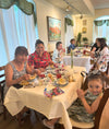 Group of women smiling at a tea party table.