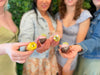Women gathered outdoors holding petit fours.