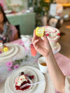 Hand raising dessert at a tea party.