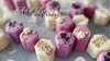 Assorted purple and white floral petit fours with sugar flowers.