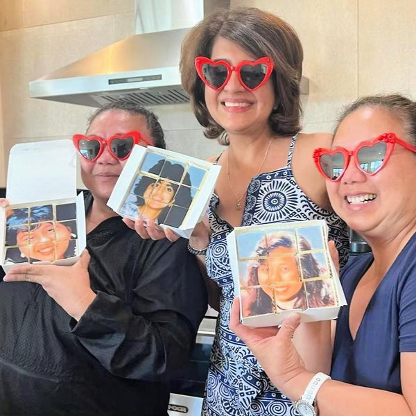Three people smiling and holding custom photo cookies.