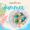 Summer-themed petit fours with beach and tropical designs on pastel background.